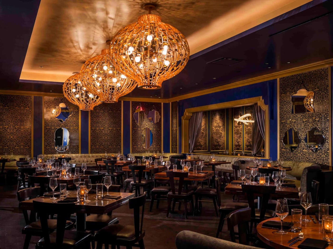 Beauty & Essex main dining room with gold lantern chandeliers and jewel-toned walls